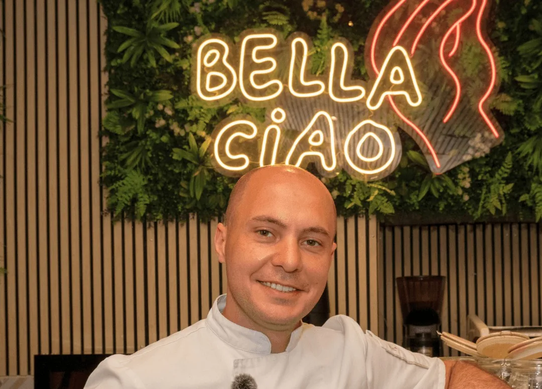Raffaele under the Bella Ciao neon on the green wall in Vieux Nice
