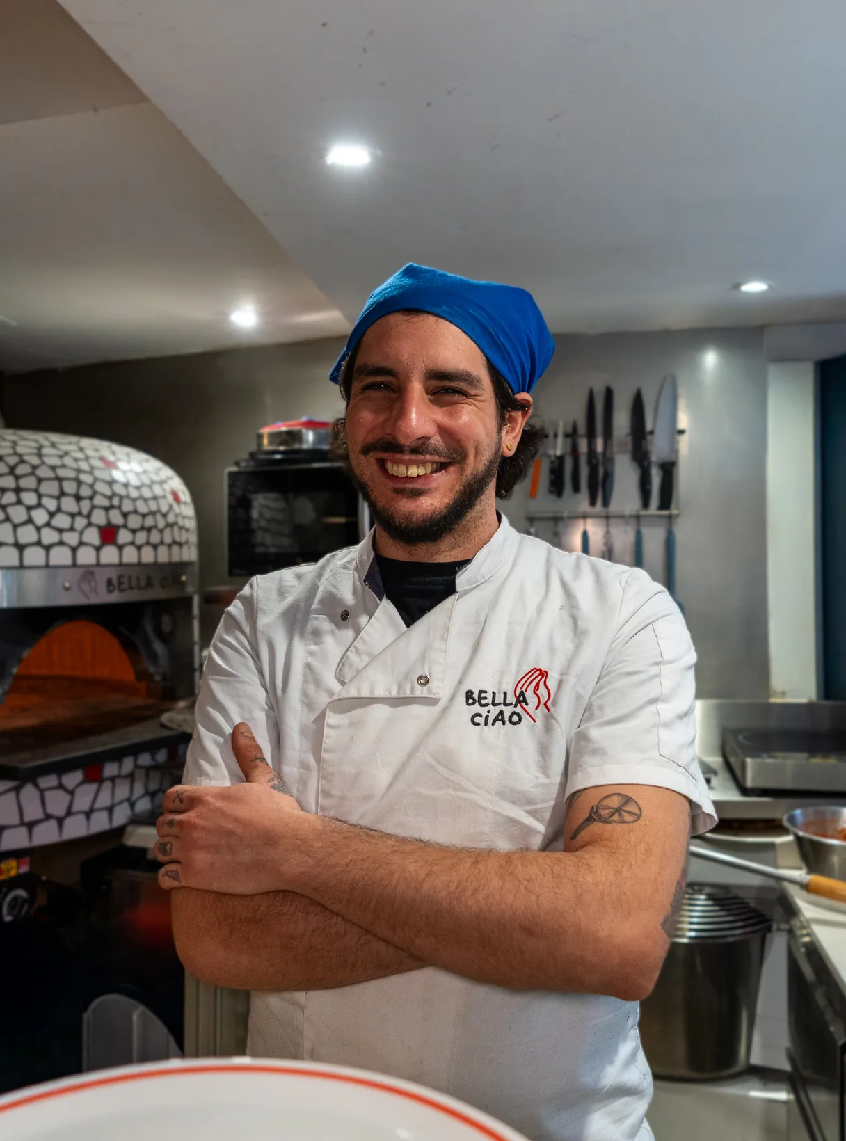 The pizzaiolo in his Bella Ciao chef jacket in front of the oven