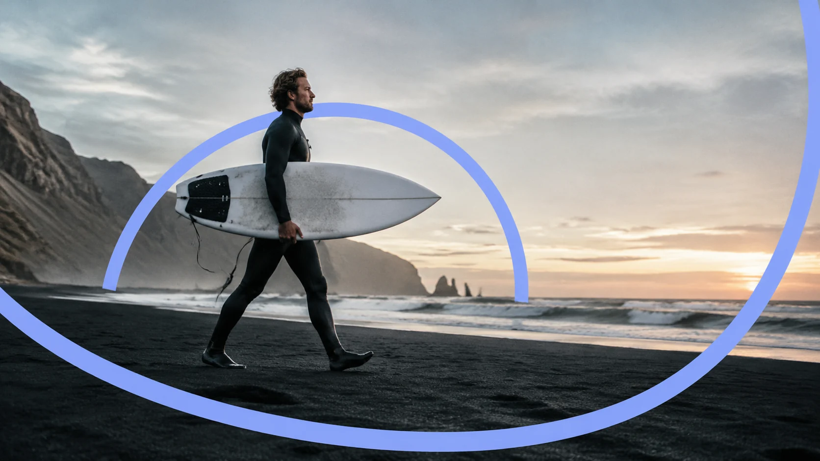 A surfer walking a black sand beach with his board, a blue ribbon looping behind him and in front of the sand